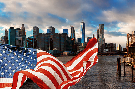 American flag flying and Brooklyn Bridge in New York City Manhattan