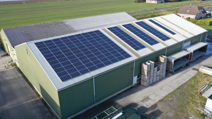 Flower bulb company with solar panels in a row on a roof. Photo taken with a drone